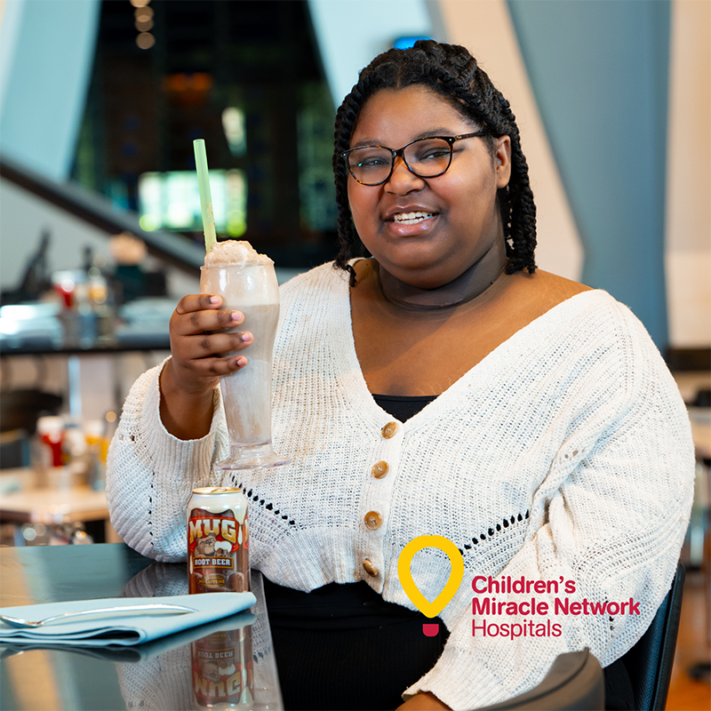 Female smiling and holding root beer float