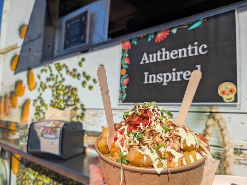 A bowl of food in front of CultivATE food truck.