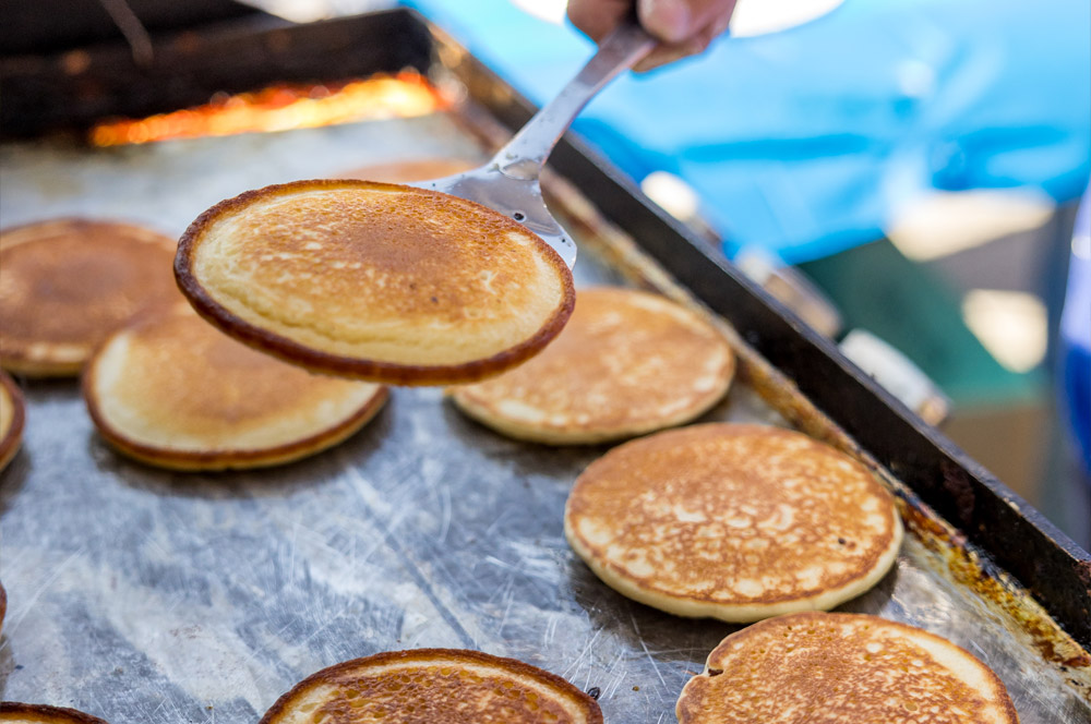 Pancake being flipped on a griddle.